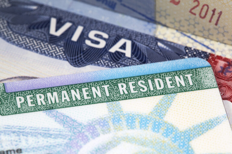 macro shot of a US green card with a passport visa in the background